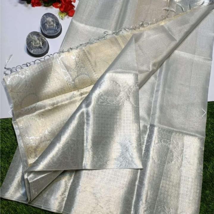Silver fabric with a textured pattern on a grassy background